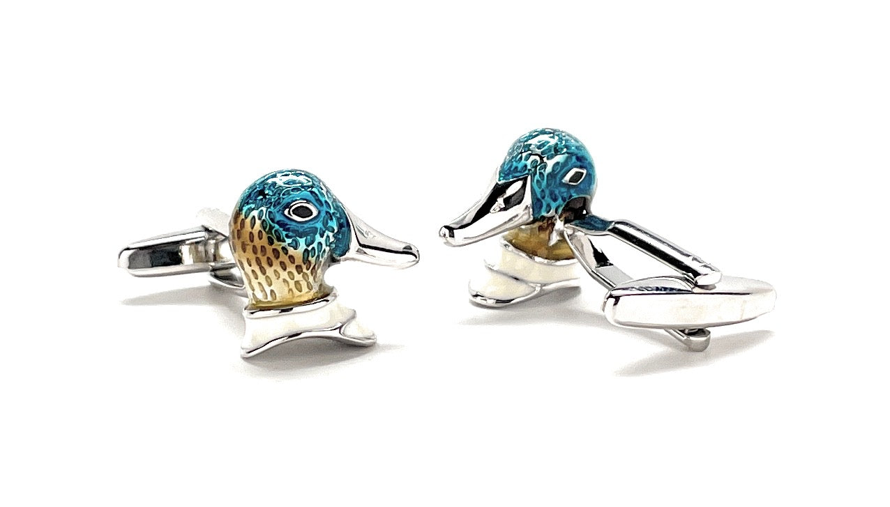 Pair of dolphin-shaped cufflinks with blue and gold accents on a white background