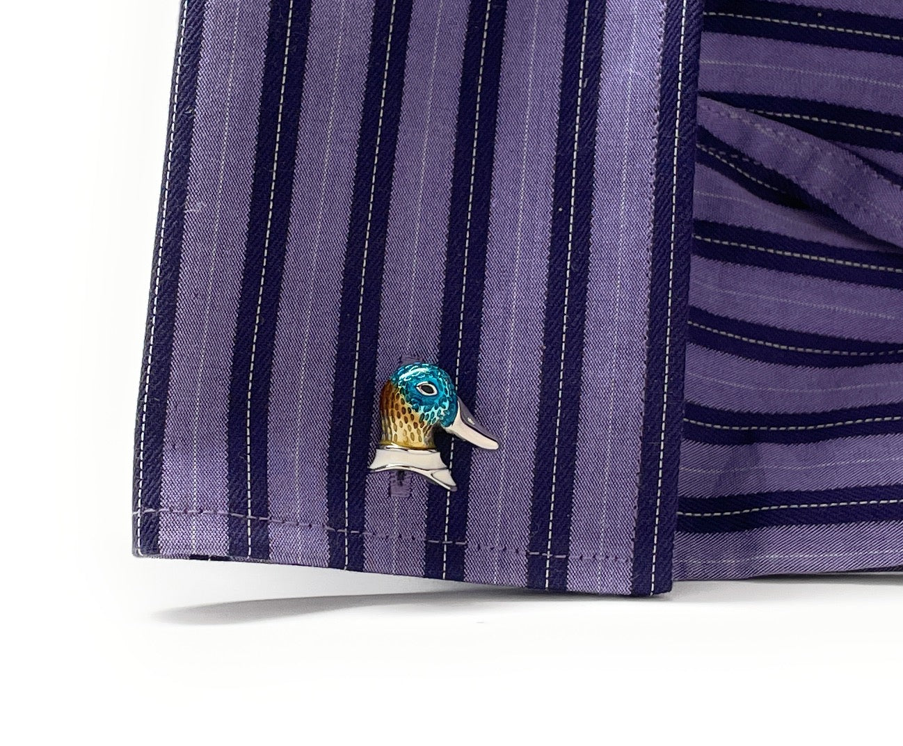 Close-up of a purple striped shirt with a decorative bird pin on a white background