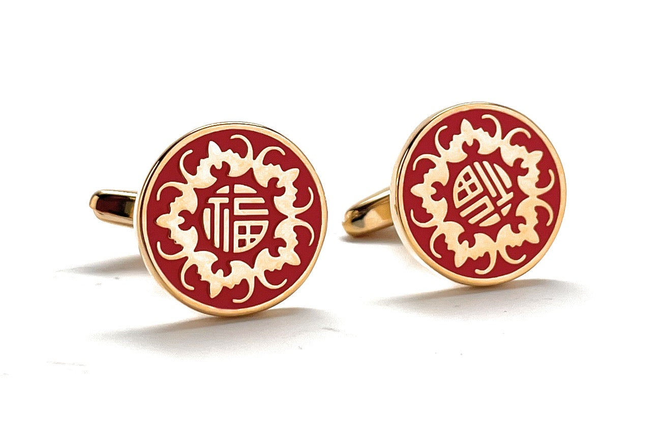 Red and gold cufflinks with intricate designs on a white background