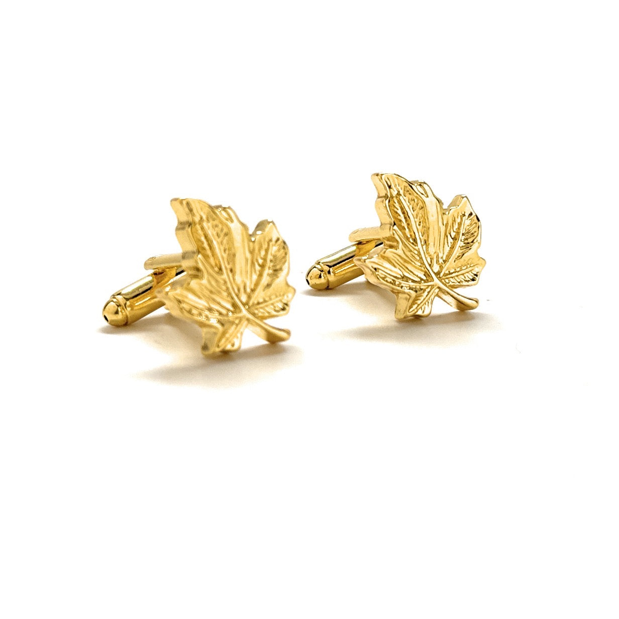 Gold leaf-shaped cufflinks on a white background