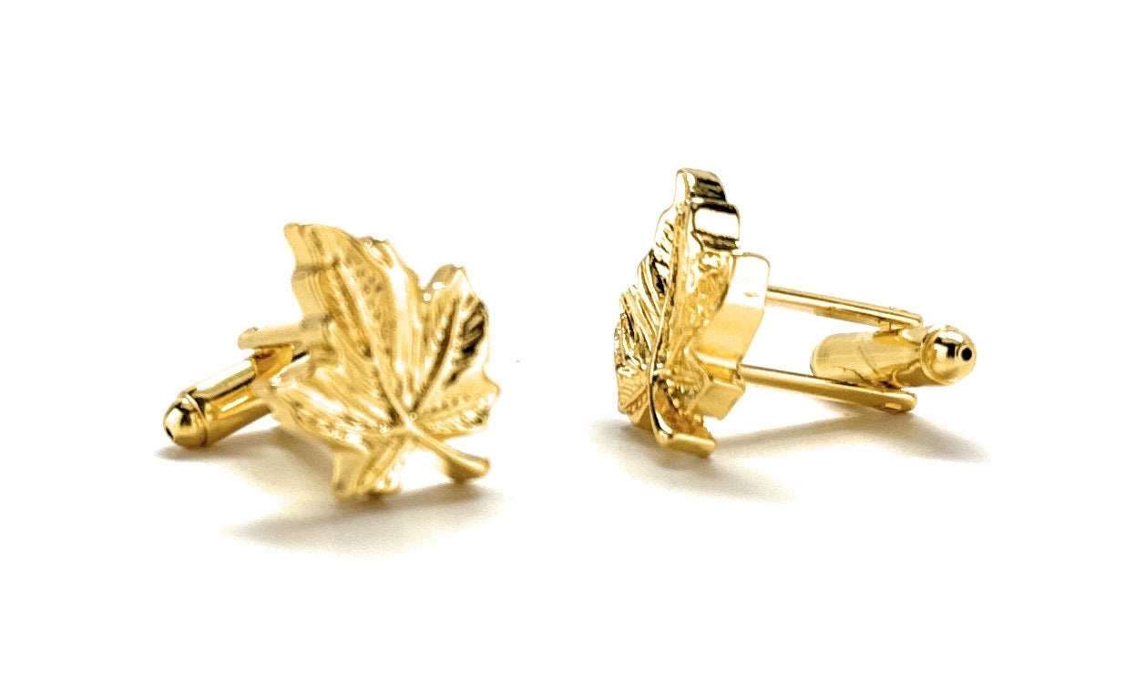 Gold leaf-shaped cufflinks on a white background