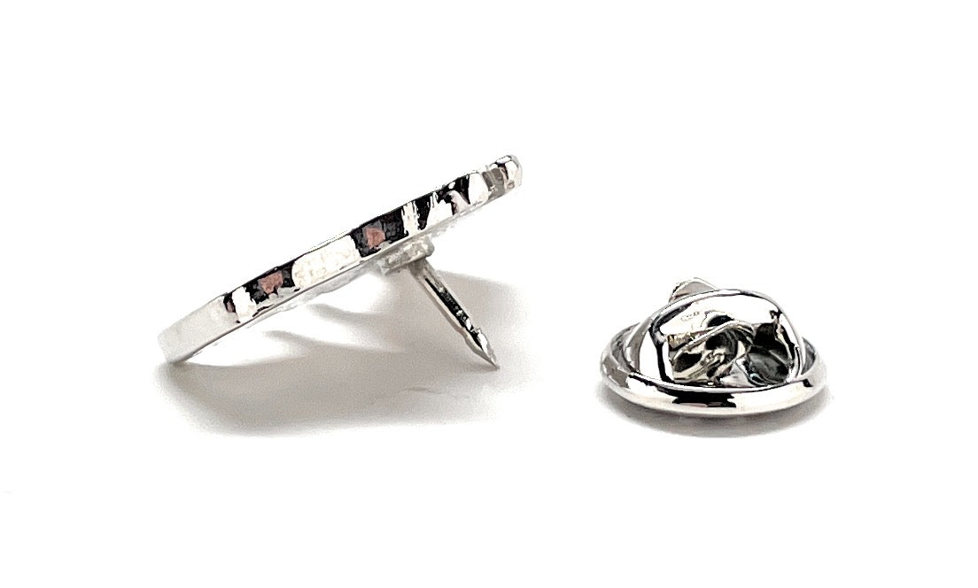 Silver ring and matching brooch on a white background