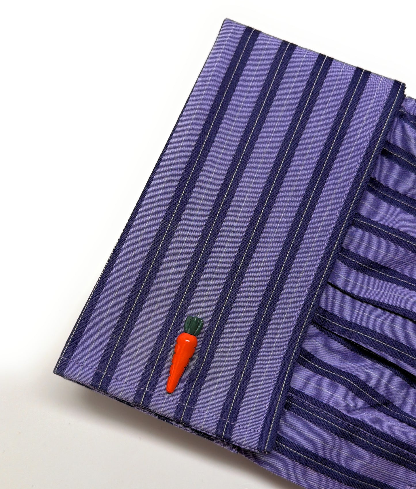 Purple striped fabric with a carrot-shaped button on a white background