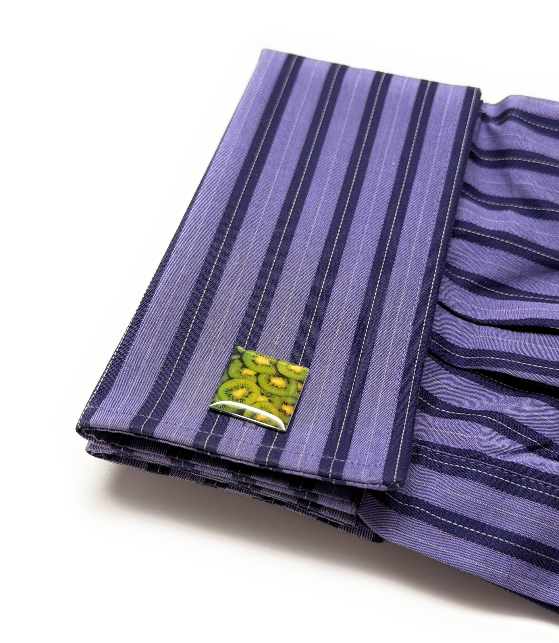 Purple striped fabric with a green tag on a white background