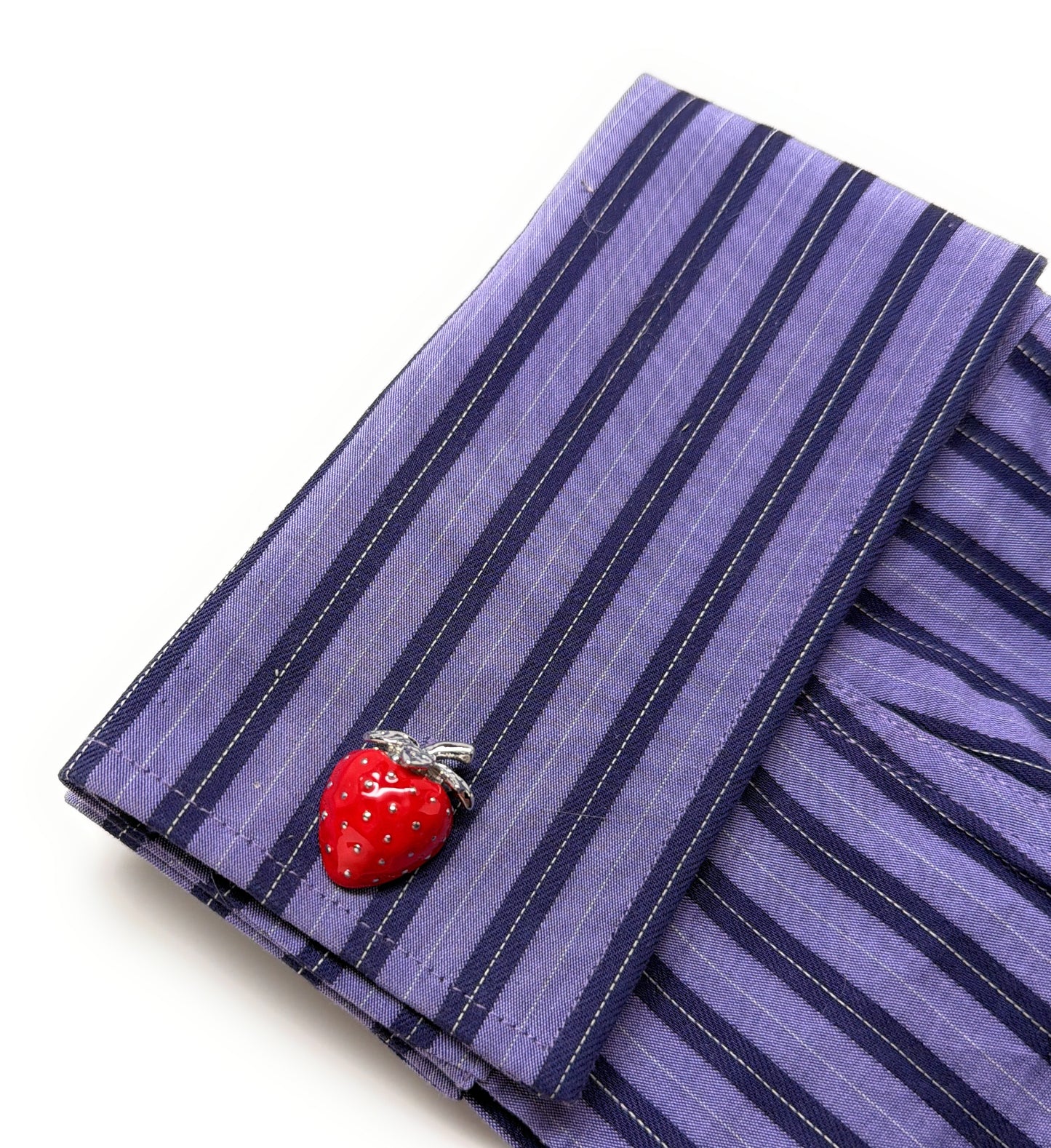 Purple striped fabric with a red strawberry-shaped cufflinks on a white background