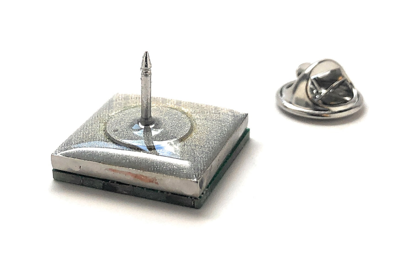 Silver lapel pin with a small round component on a white background