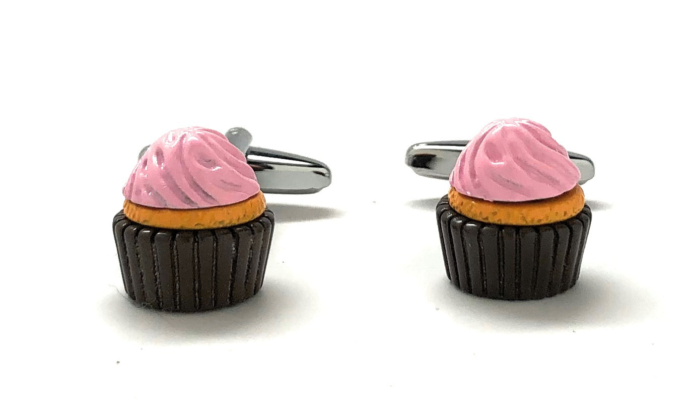 Cupcake-shaped cufflinks with pink frosting and black bases on a white background