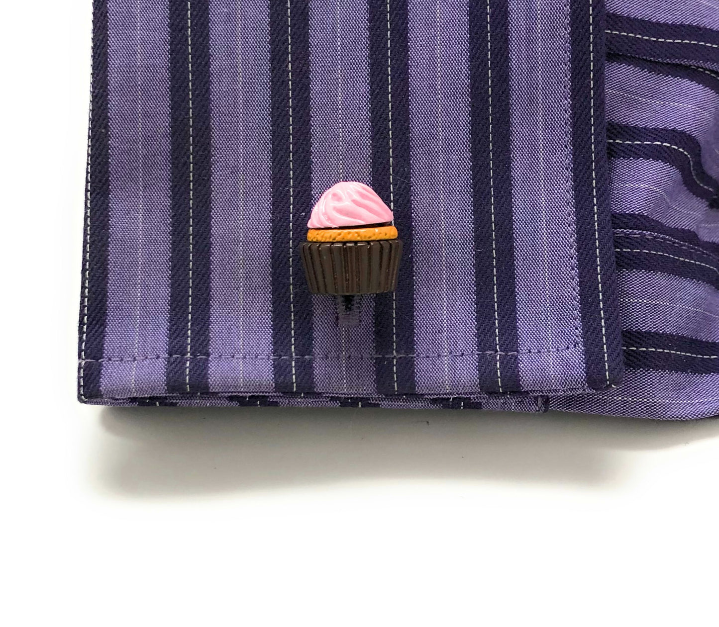 Cupcake-shaped brooch on a striped shirt
