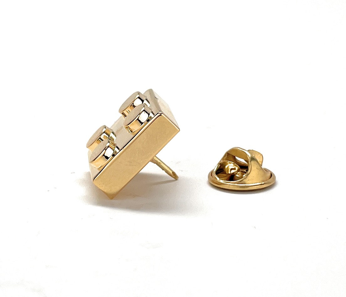 Gold metal lapel pin on a white background