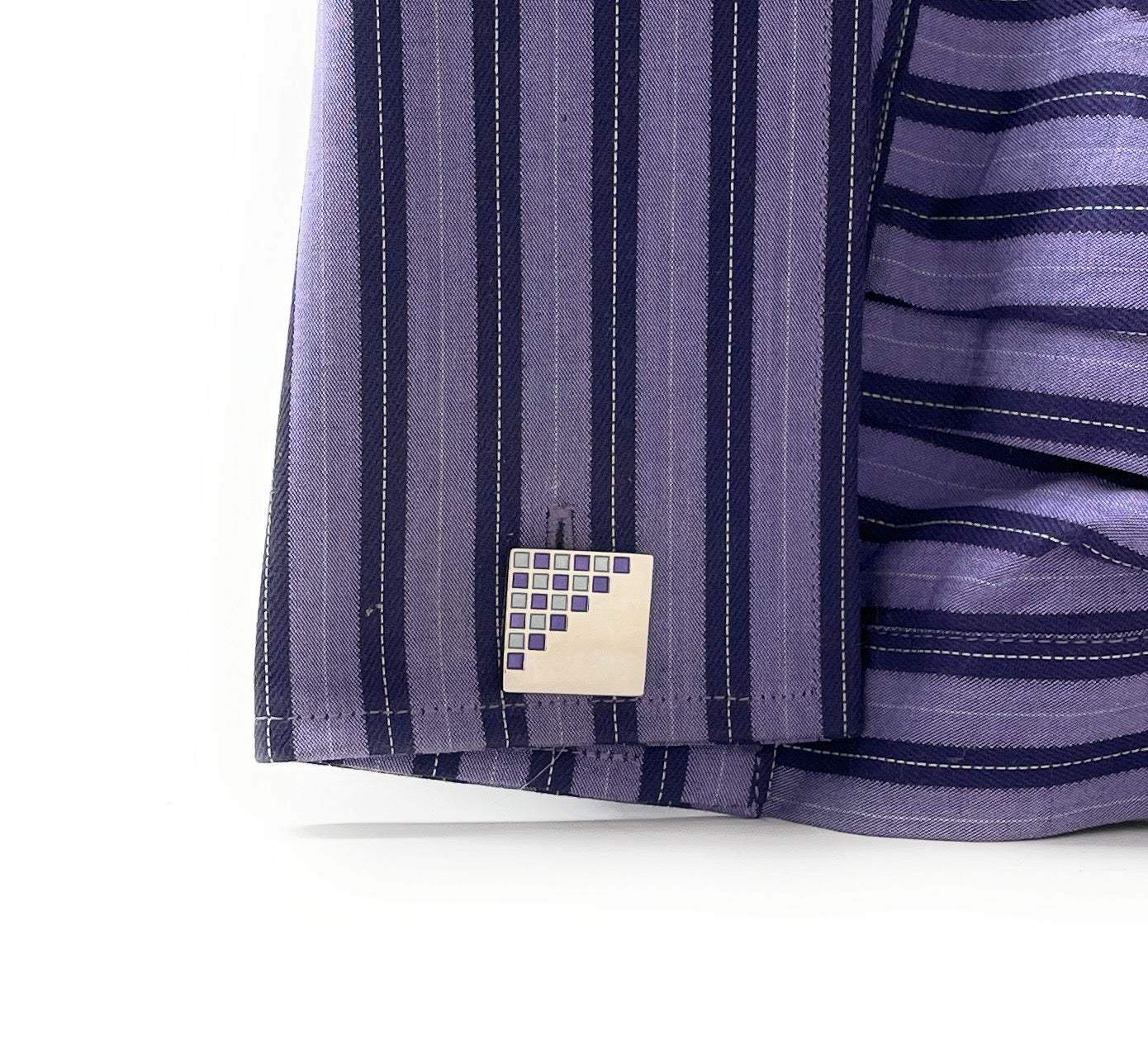 Close-up of a purple striped fabric with a brand label on a white background