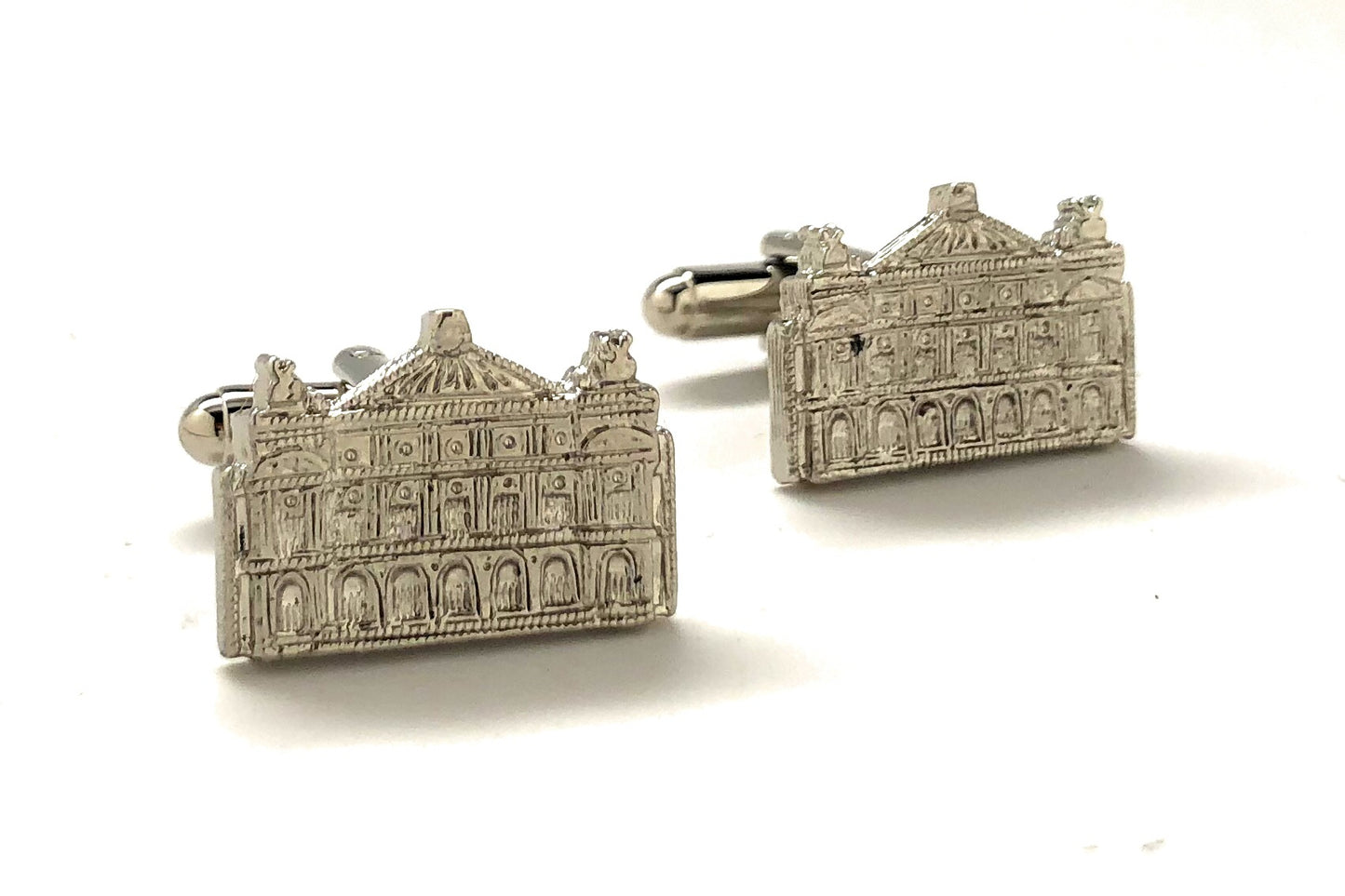 Silver architectural cufflinks on a white background