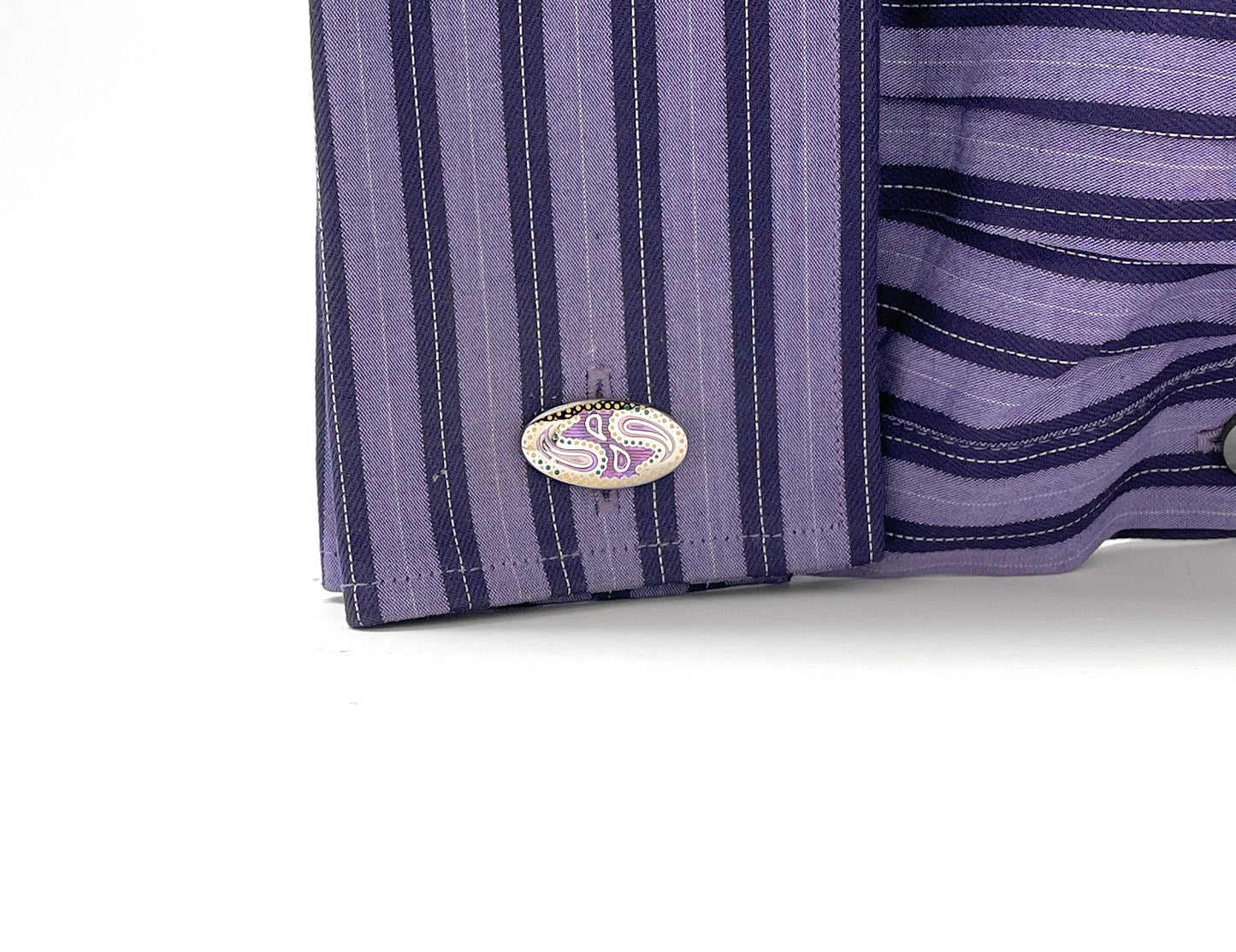 Close-up of a purple and blue striped shirt with a brand logo on a white background