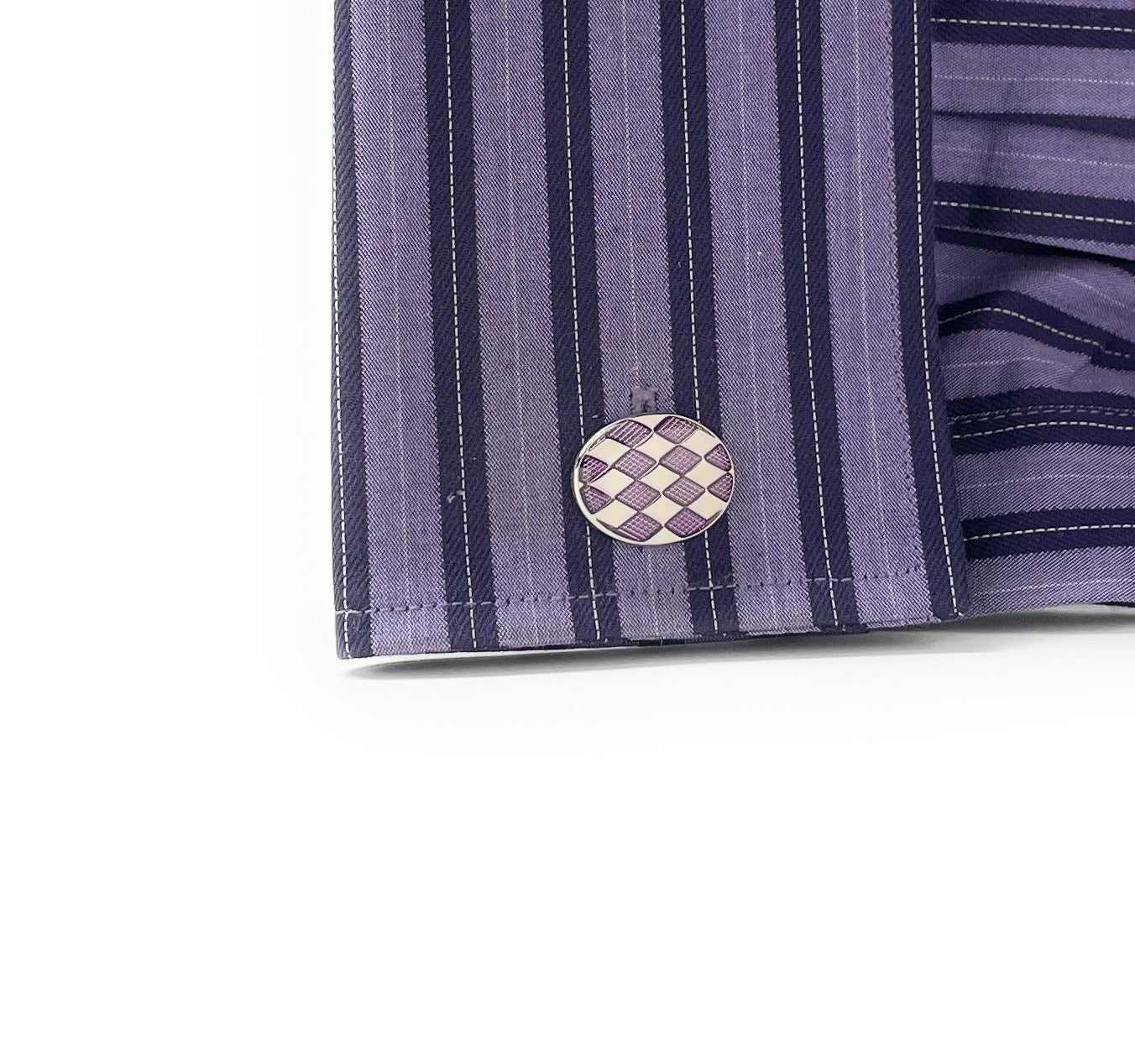 Close-up of a purple striped shirt with a checkered cufflink on a white background
