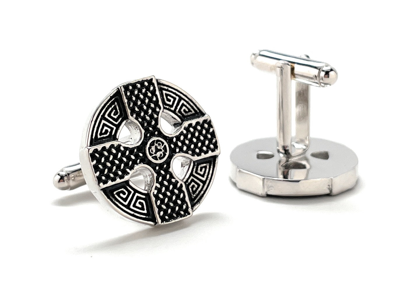 Cufflinks with intricate design on a white background