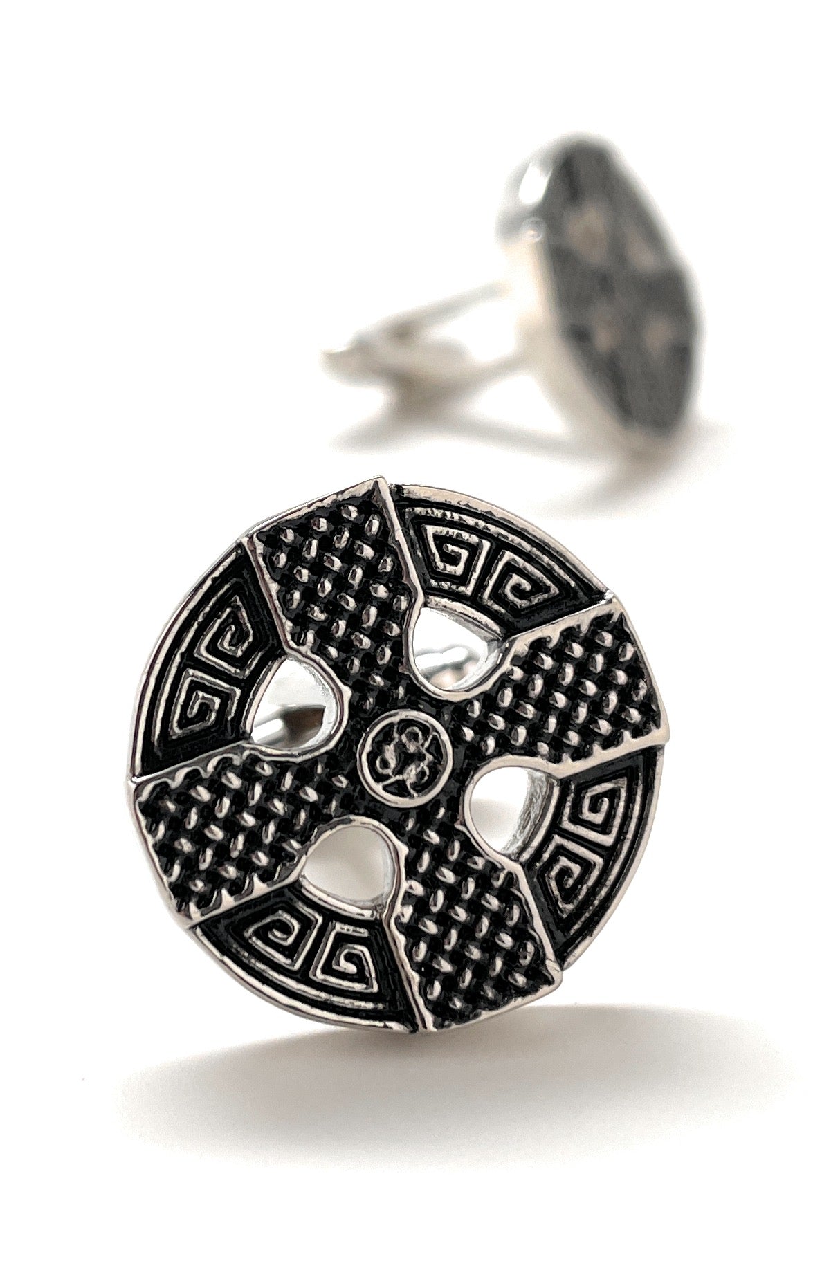 Silver ring with intricate design on a white background