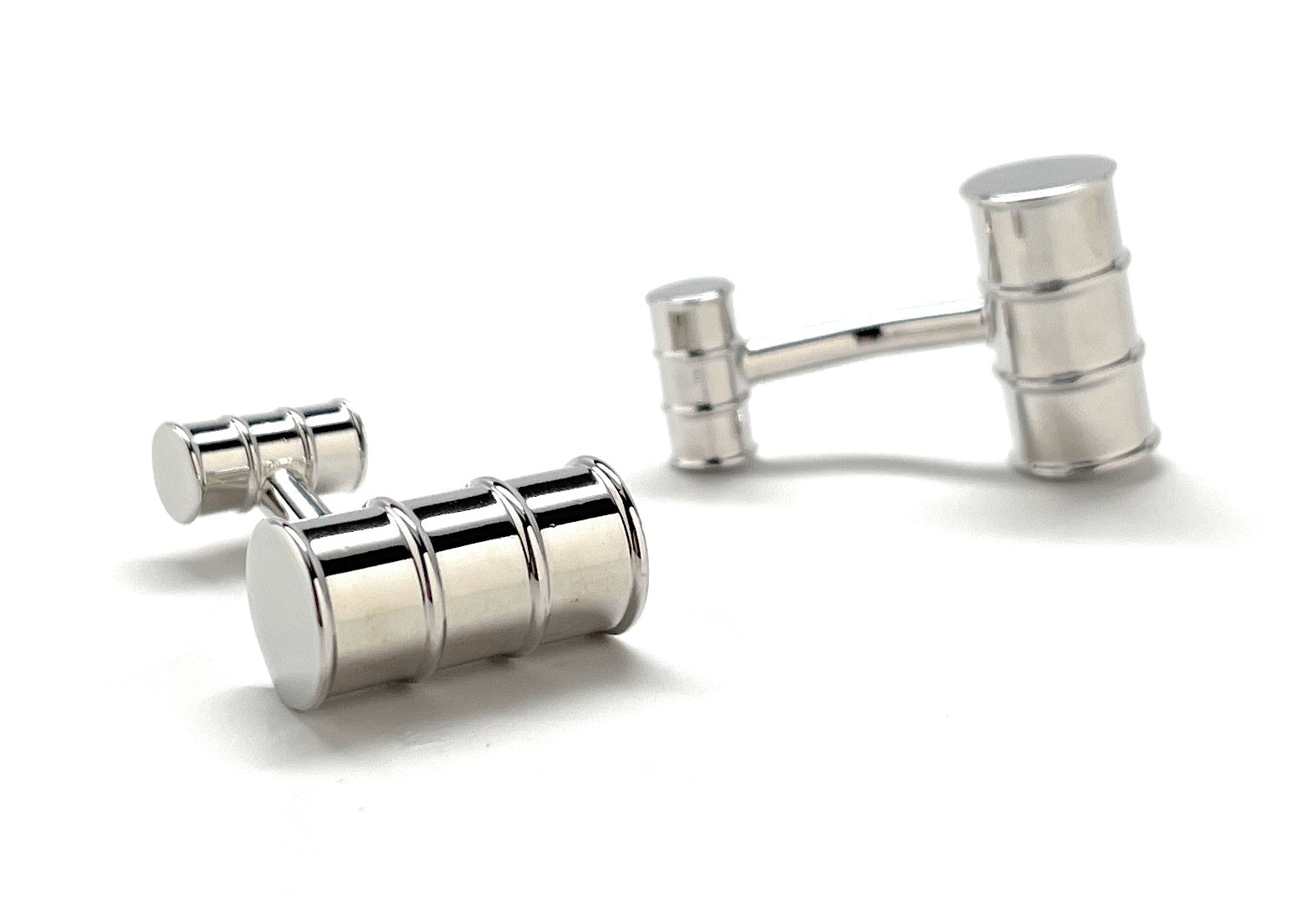 Silver cylindrical cufflinks on a white background