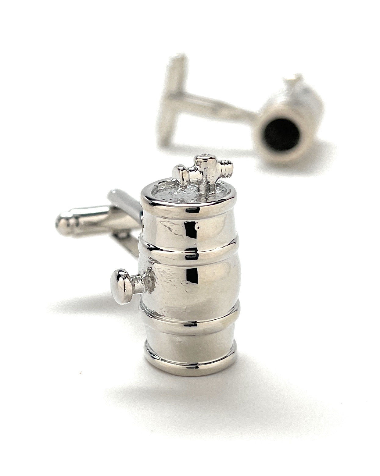 Silver cufflinks designed like a vintage camera lens on a white background