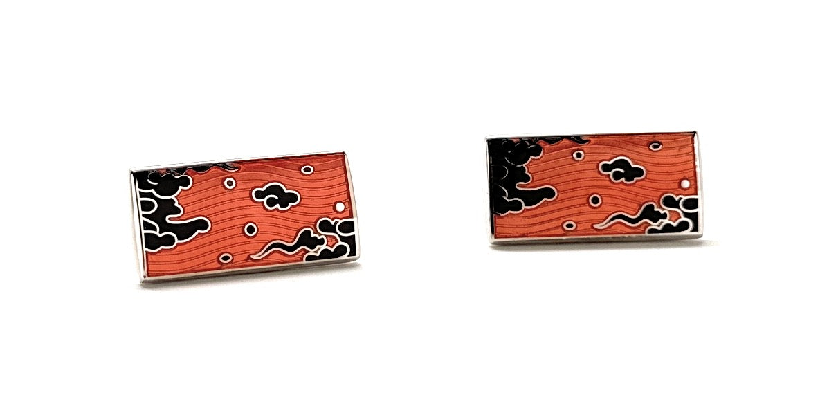 Two red rectangular pins with black cloud patterns on a white background