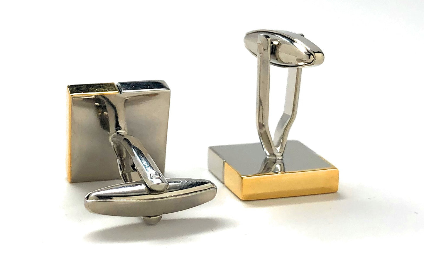 Gold and silver cufflinks on a white background