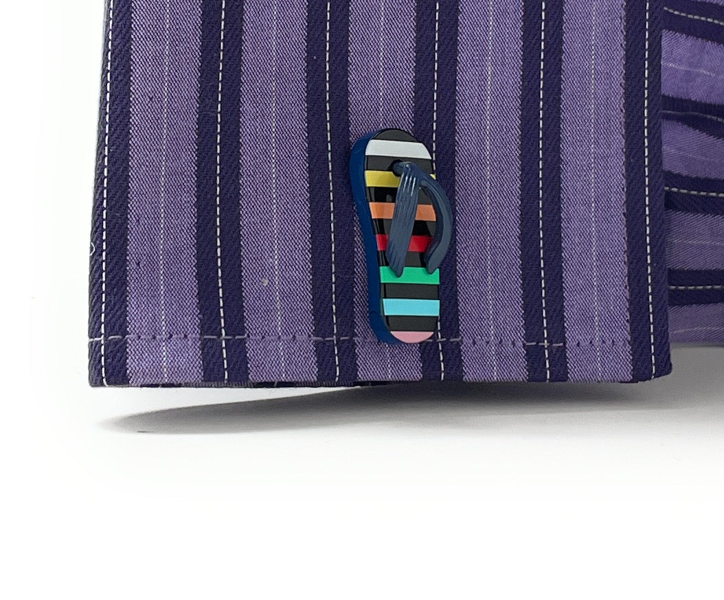 Close-up of a purple striped shirt with a colorful flip-flop button on a white background