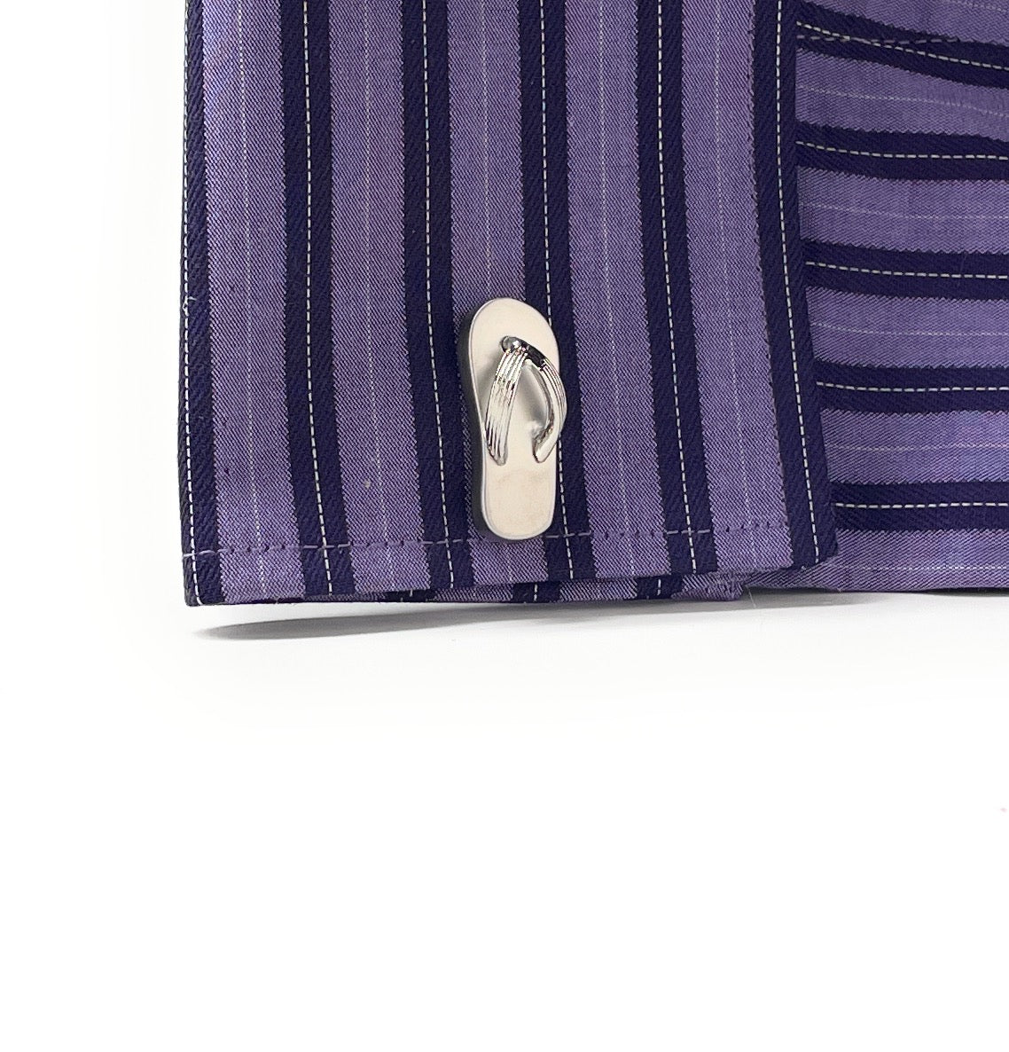 Close-up of a purple striped shirt with a button on a white background