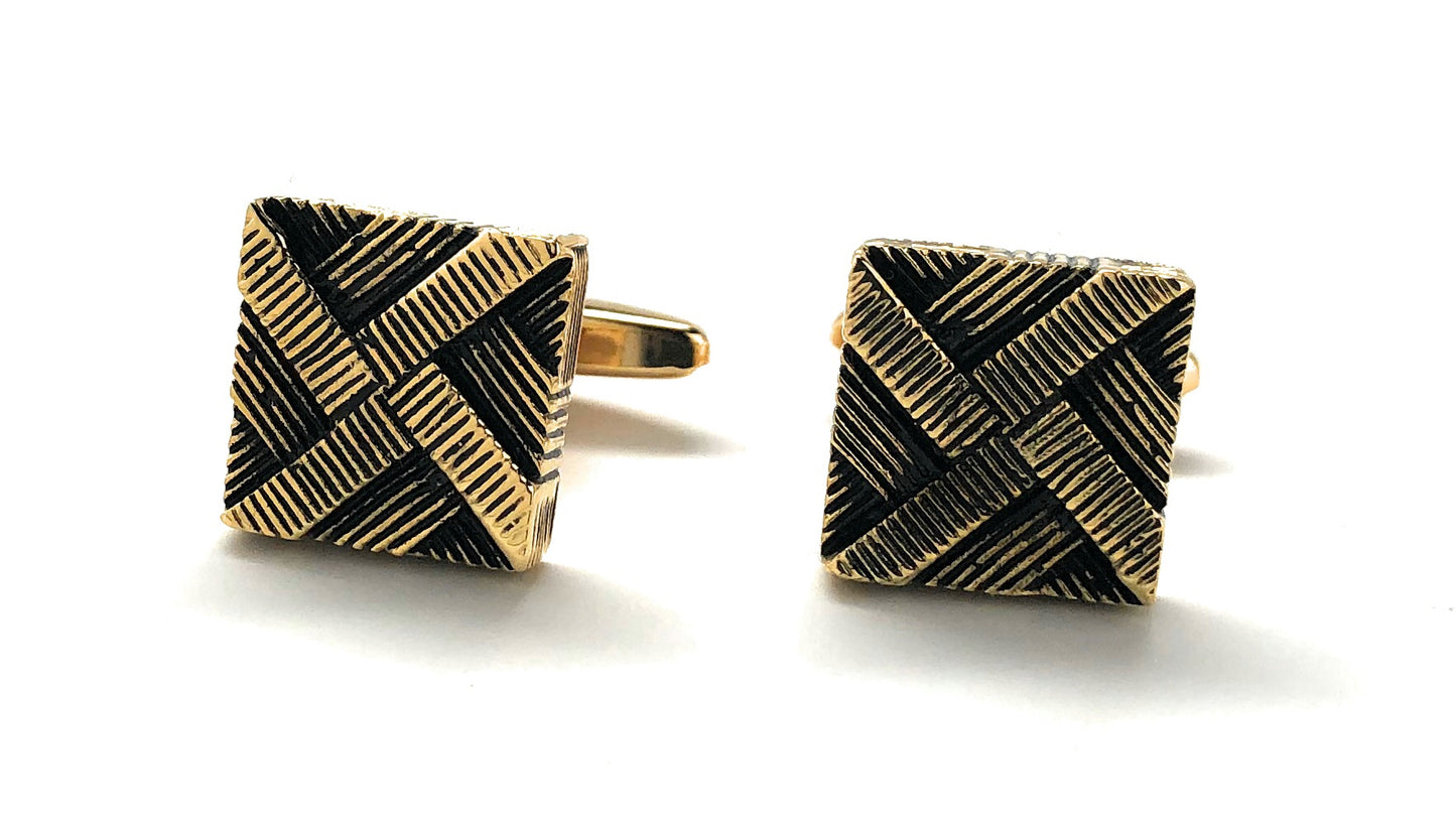 Pair of square cufflinks with gold and black pattern on a white background