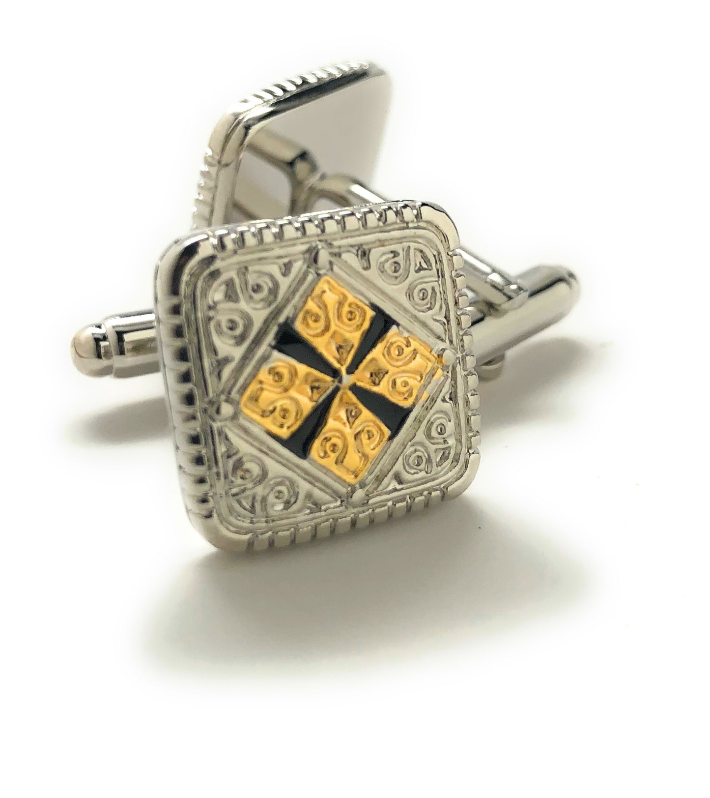 Silver cufflink with gold and black design on a white background