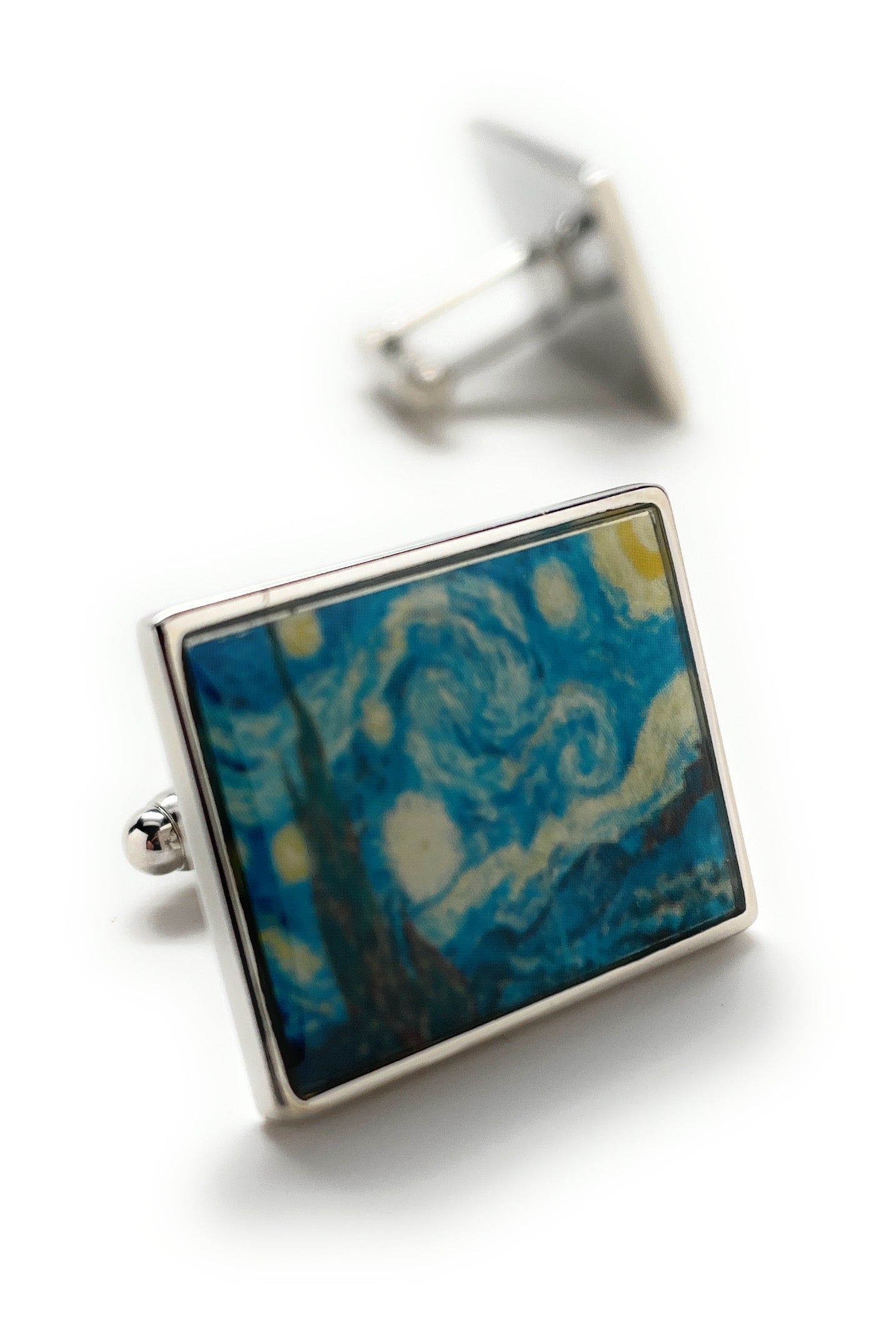 Cufflinks with a blue and gold abstract design on a white background