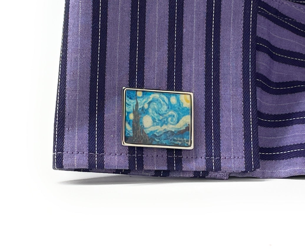 Close-up of a purple striped shirt with a Van Gogh painting pin on a white background