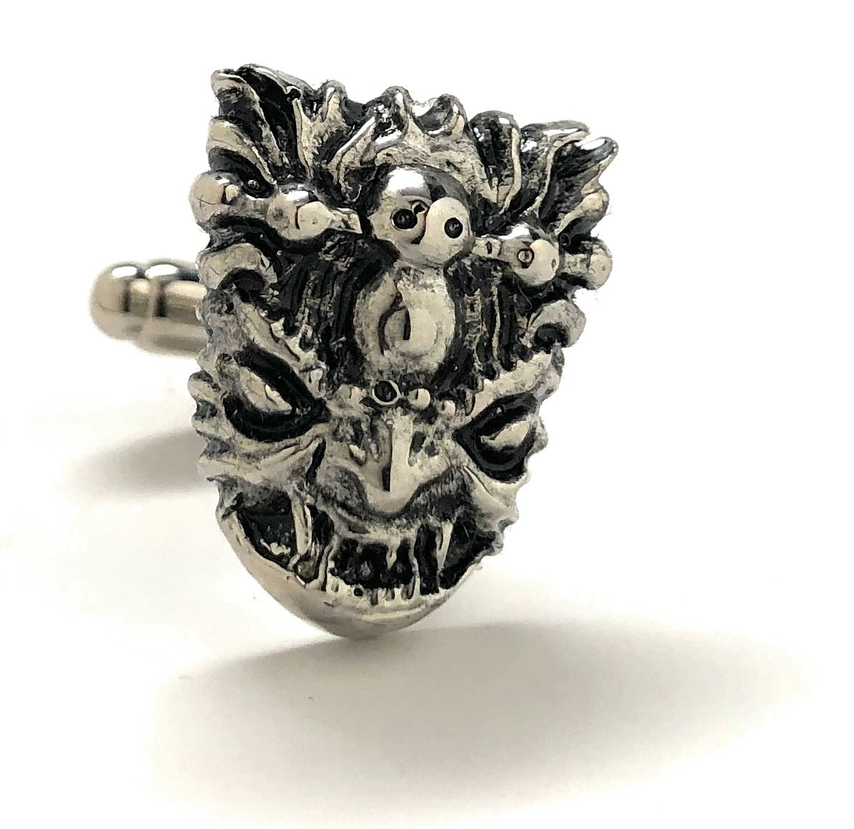Silver mask-shaped ring on a white background