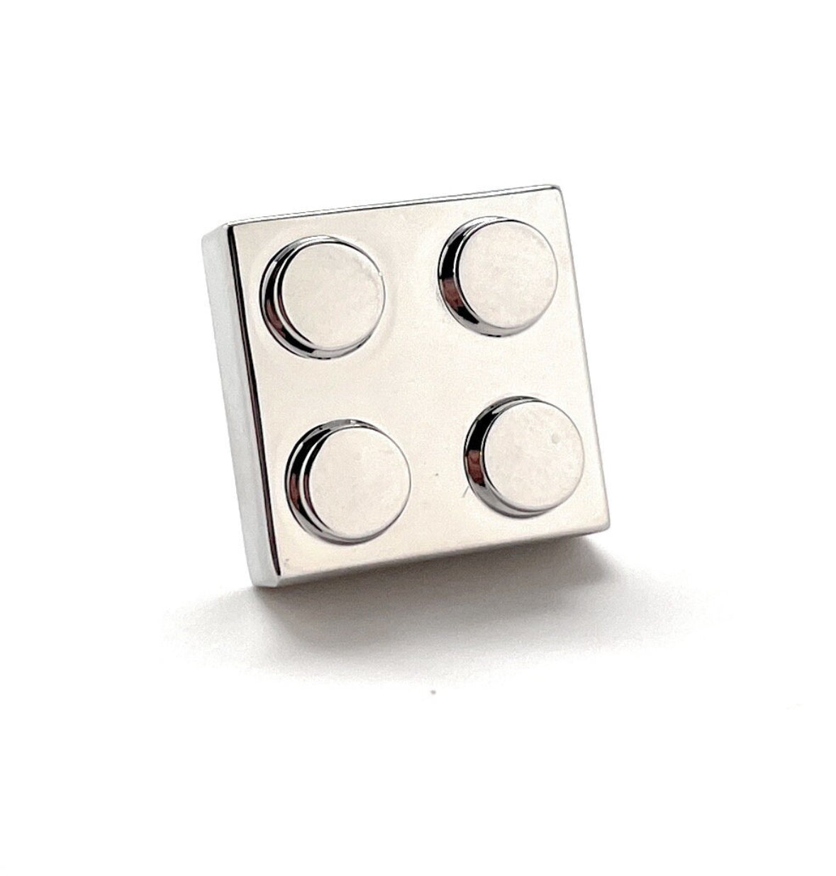 Metallic square block with circular protrusions on a white background