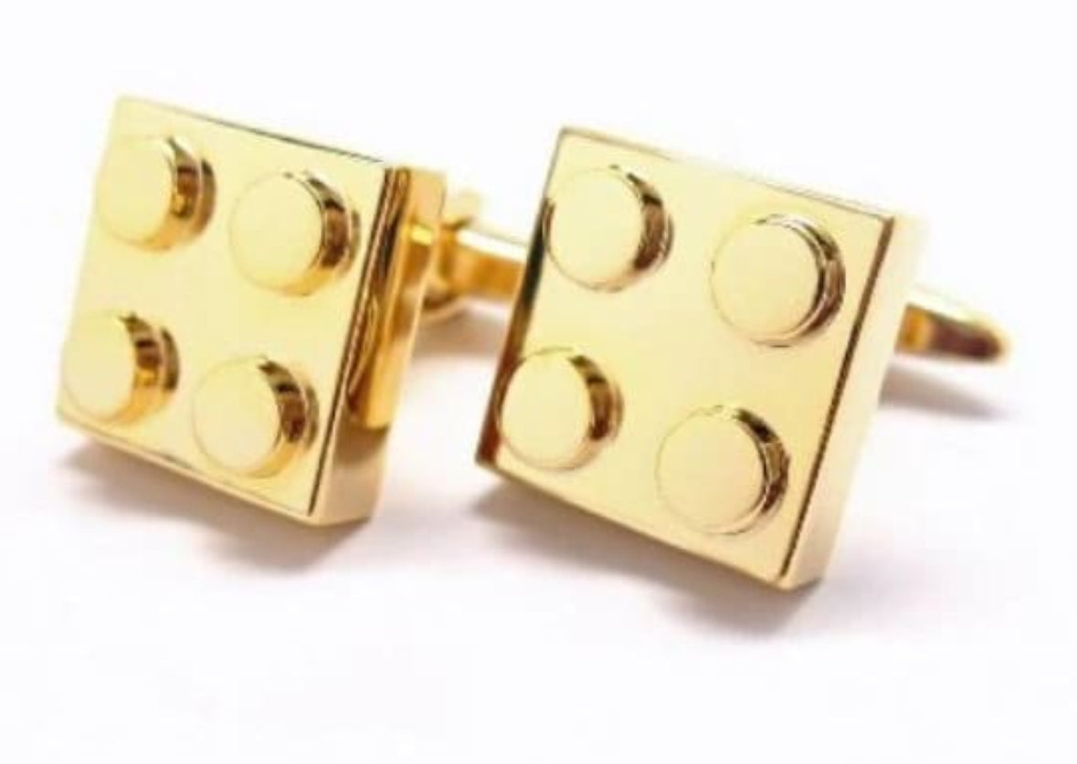 Gold brick-shaped cufflinks on a white background