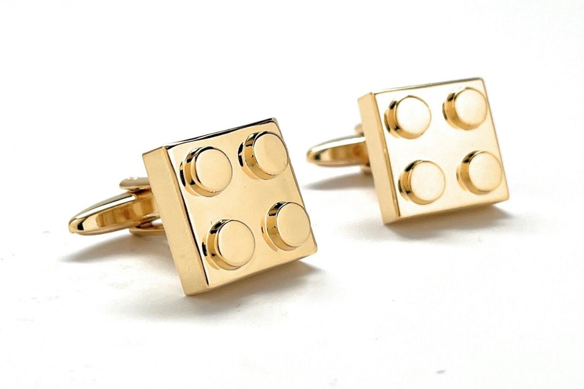 Gold square cufflinks on a white background