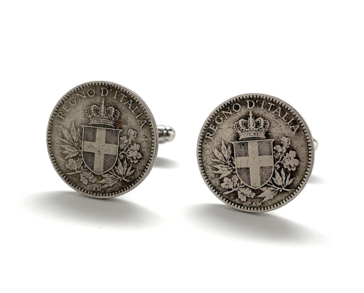 A pair of silver-colored cufflinks featuring inscriptions and national emblems, indicative of Italian origin.