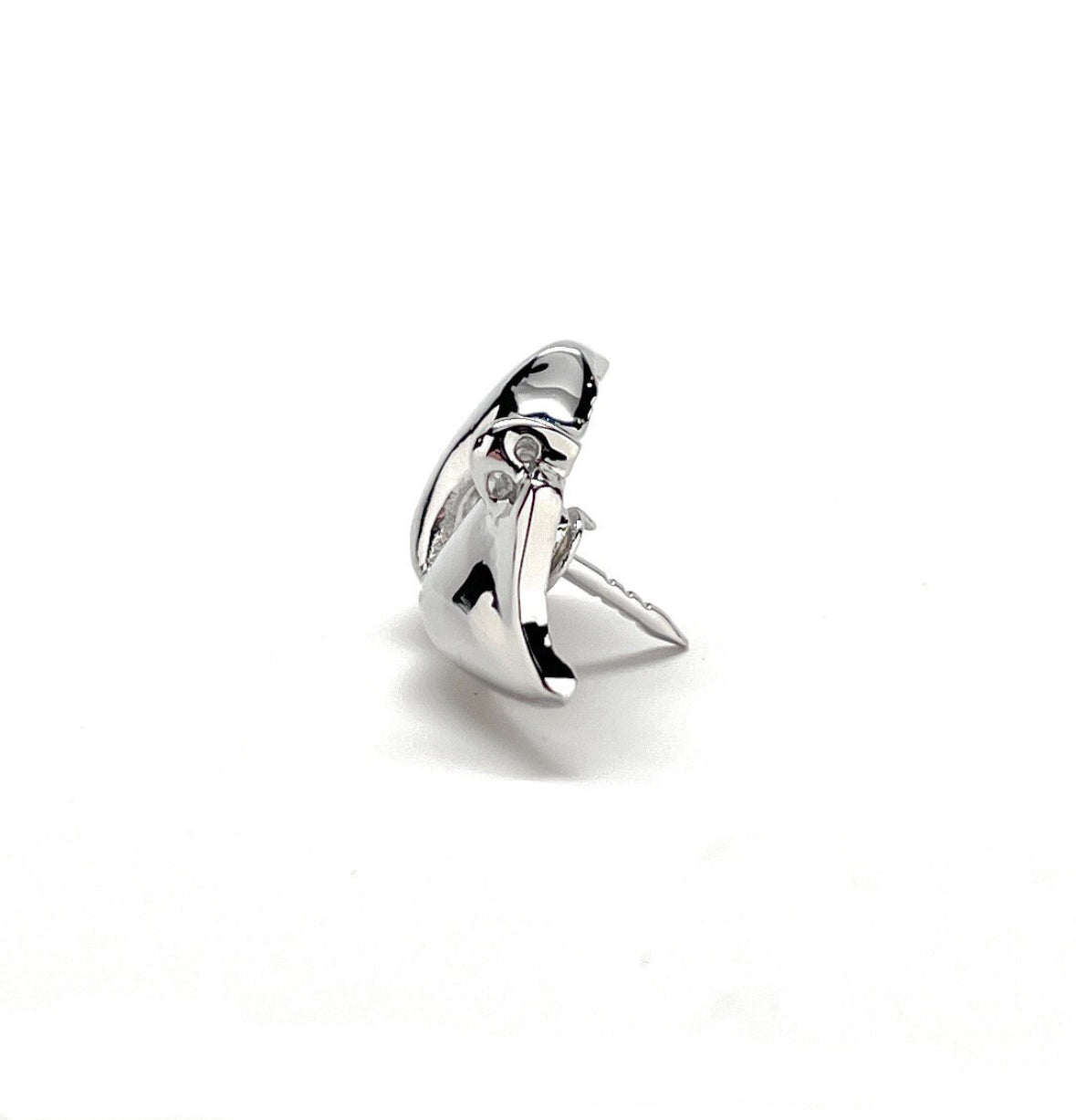 A silver-colored lapel pin in the shape of a mask, with a shiny finish and a butterfly back.