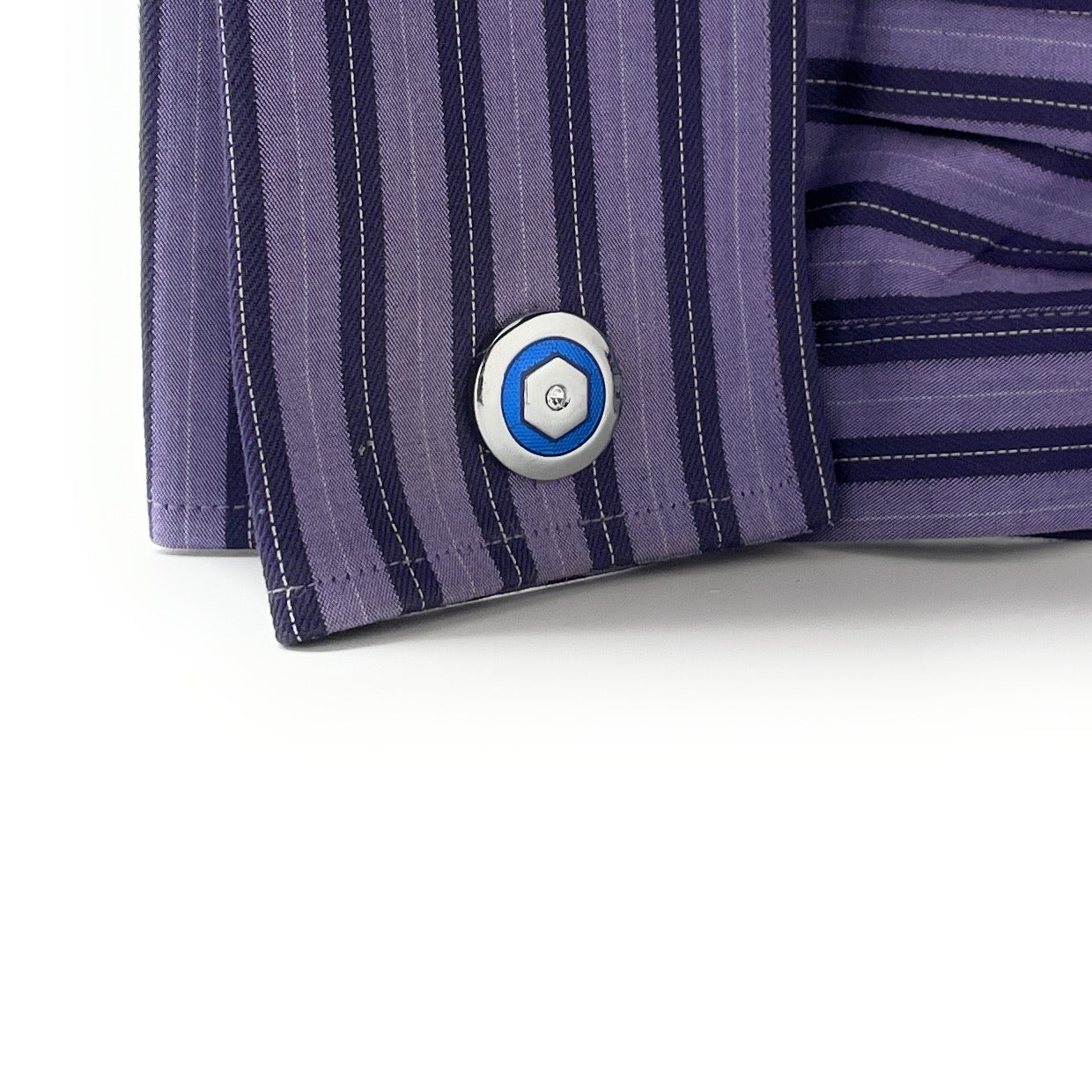 Close-up of a purple striped shirt cuff with a button on a white background