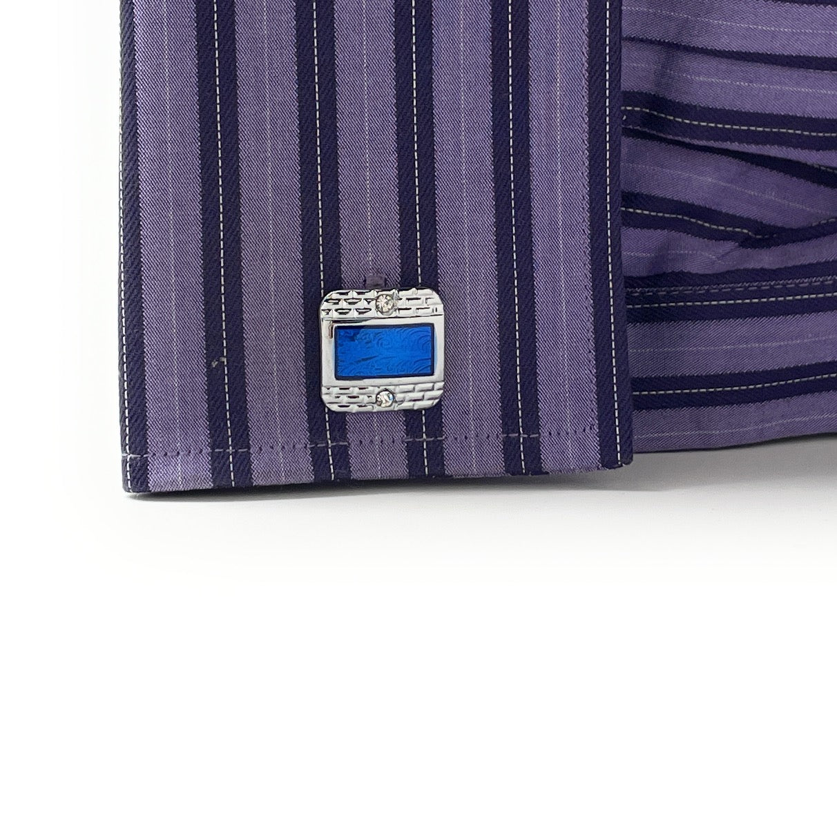 Close-up of a purple striped shirt with a decorative blue button on a white background