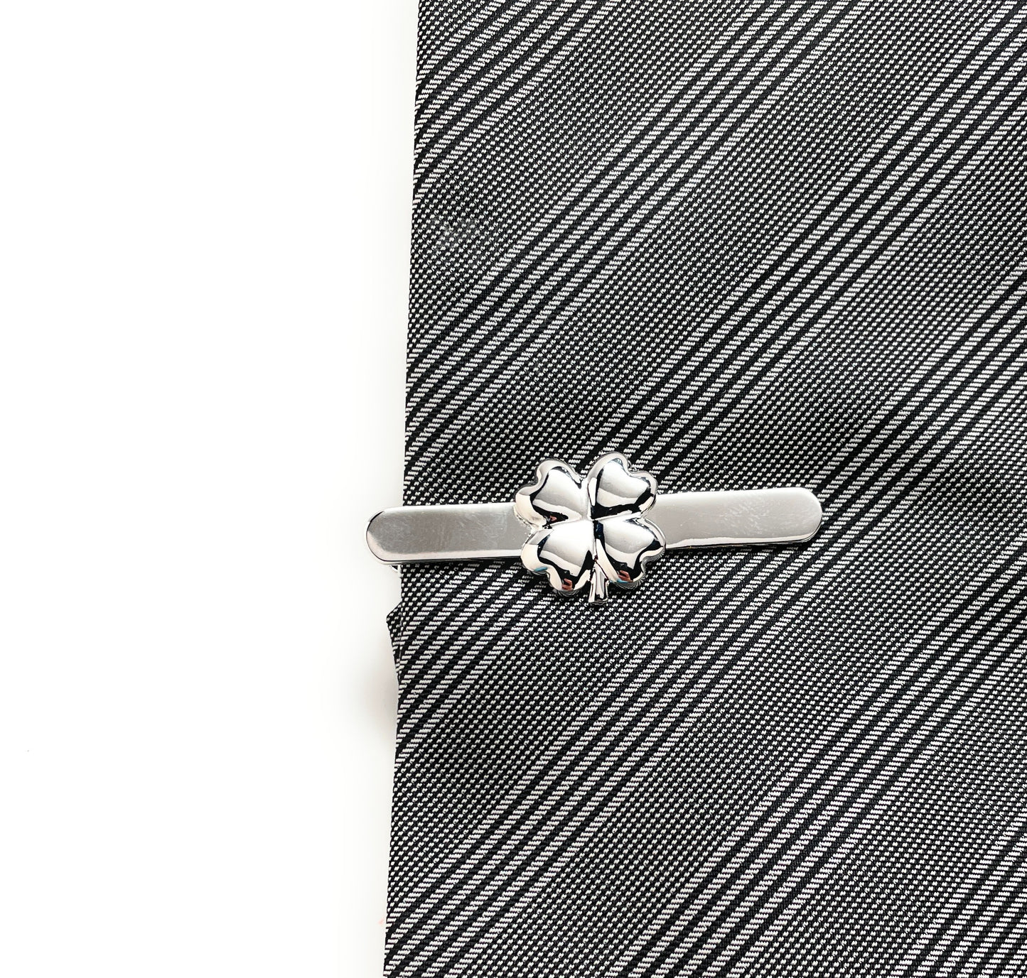 Silver tie clip on a gray striped tie