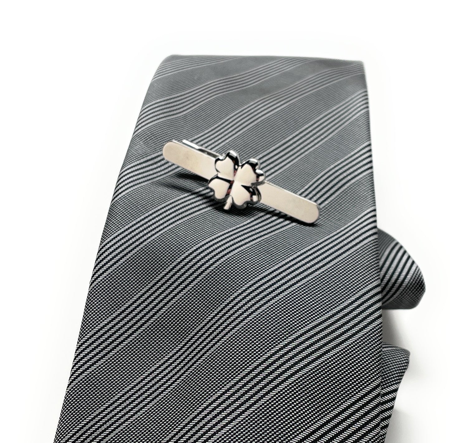Gray striped tie with a silver tie clip on a white background