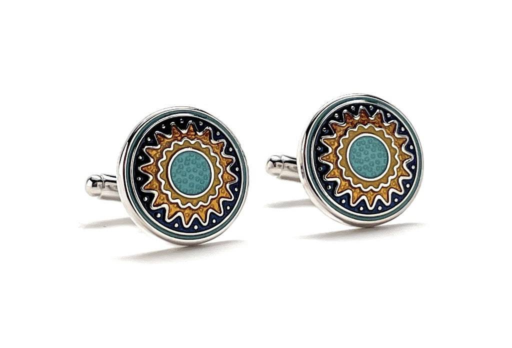 Round cufflinks with decorative design on a white background