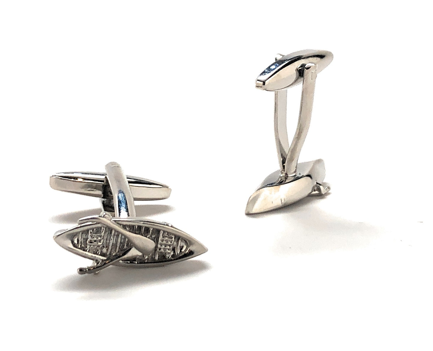 Silver cufflinks with intricate designs on a white background