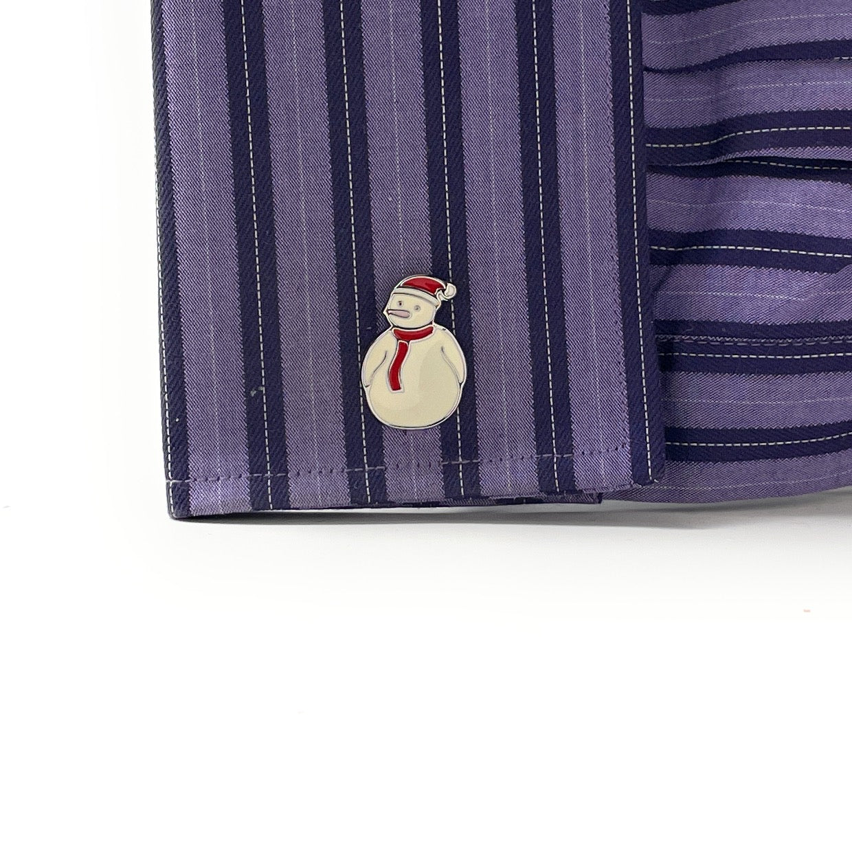 Striped fabric with a snowman pin on a white background