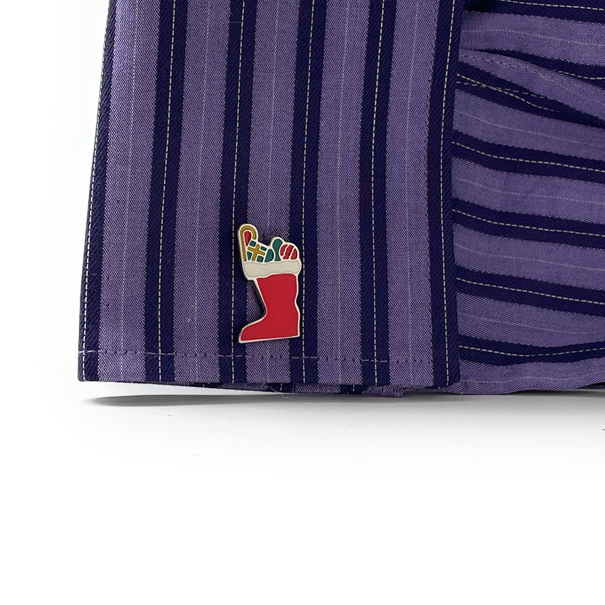 Close-up of a purple striped fabric with a colorful embroidered design on a white background