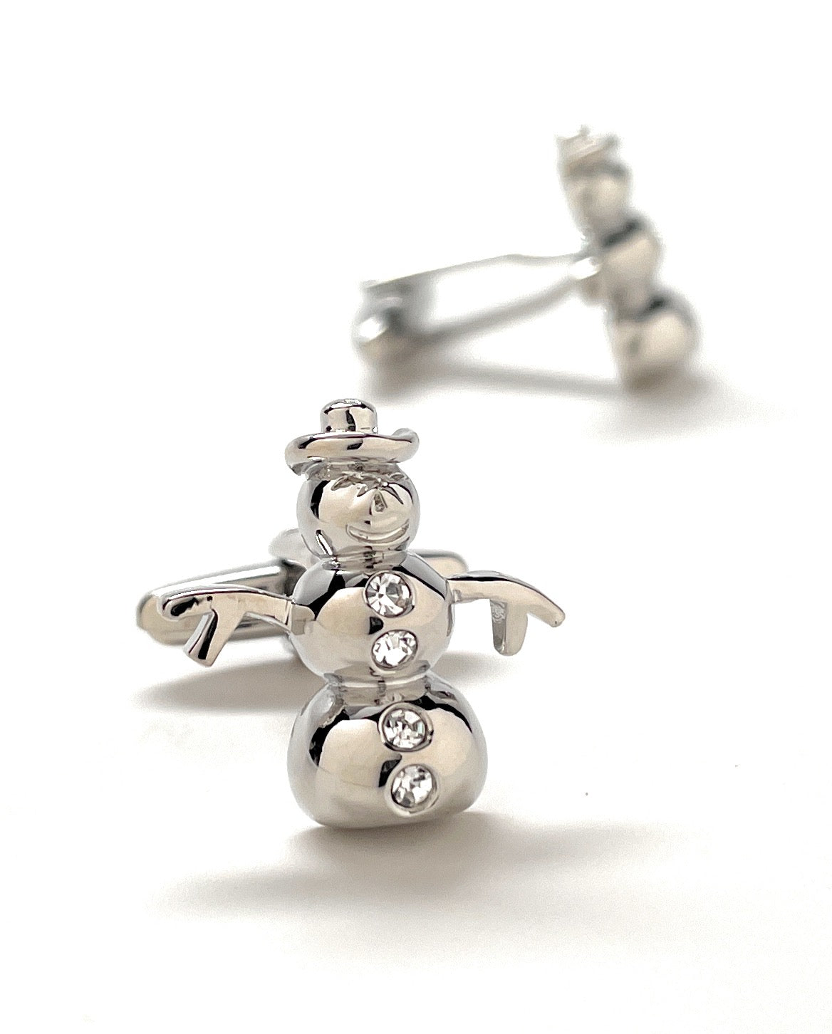 Silver snowman-shaped cufflinks on a white background