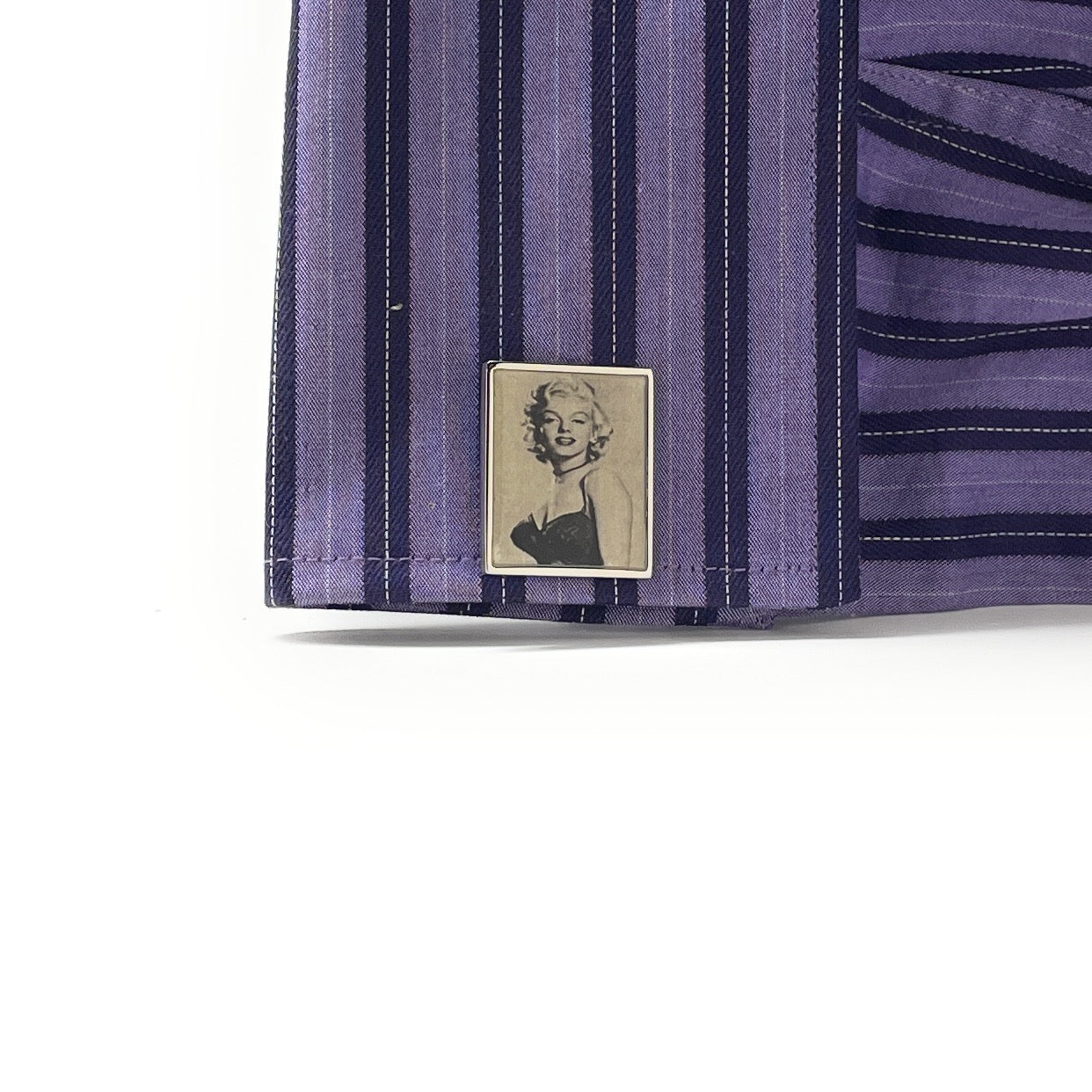 Close-up of a purple striped fabric with a logo featuring a woman's portrait on a white background