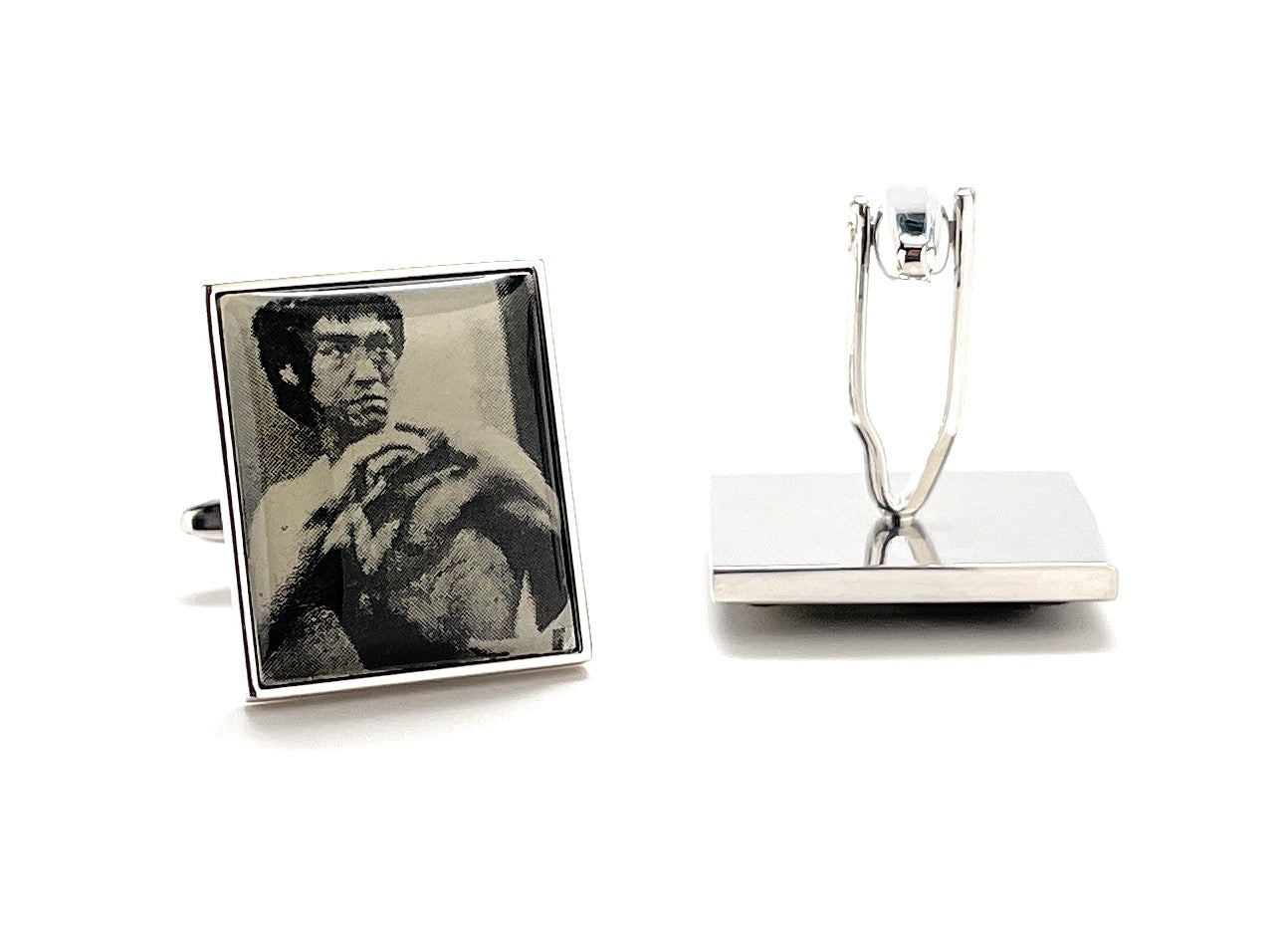 Cufflinks with a portrait of a famous person on one piece and a plain design on the other, displayed on a white background.