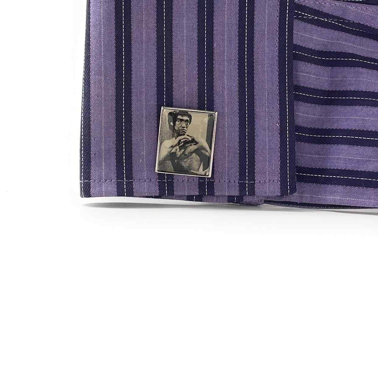 Close-up of a purple striped shirt with a small square patch featuring a person on a white background