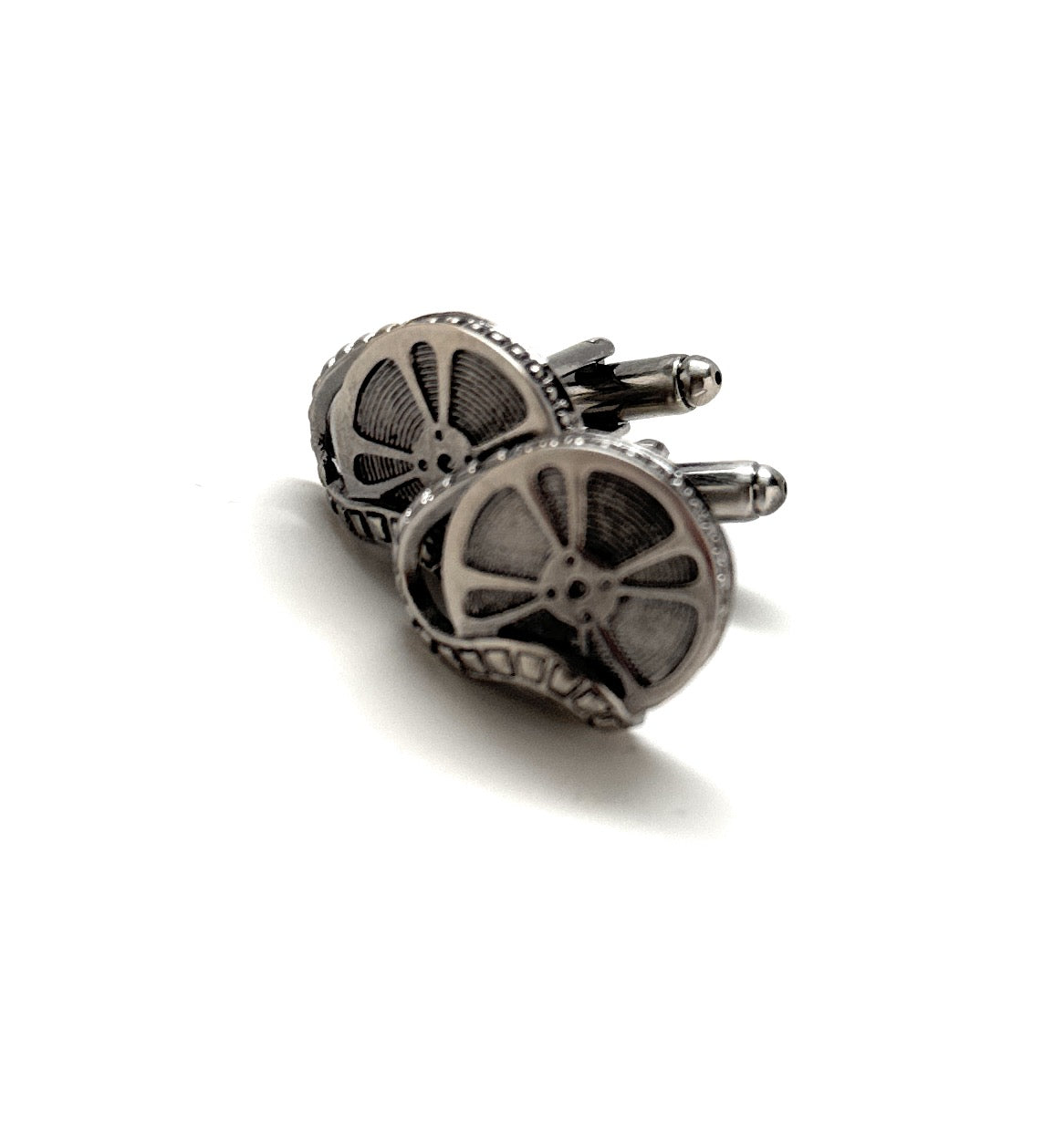 Pair of silver gear cufflinks on a white background