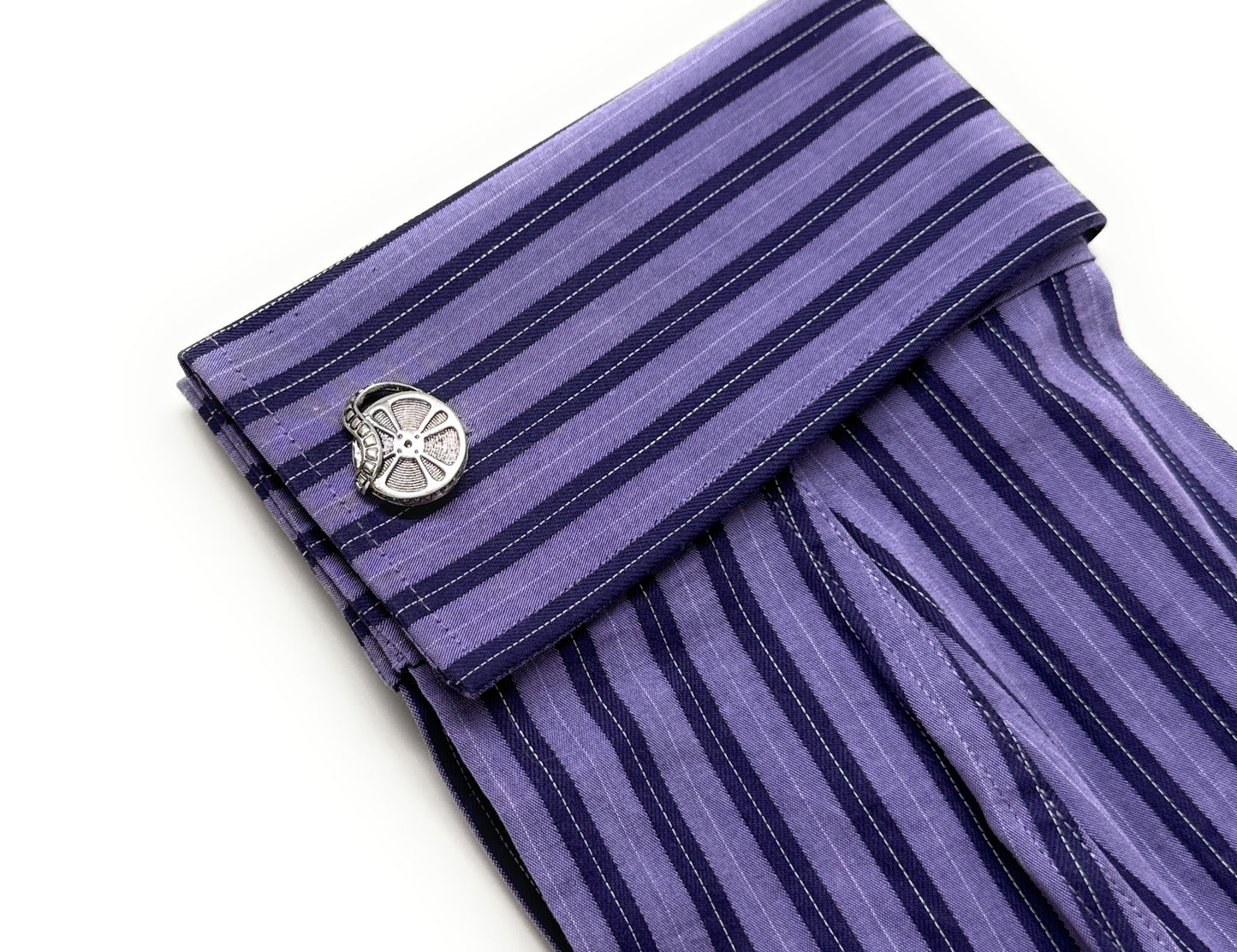 Purple striped cufflink on a white background