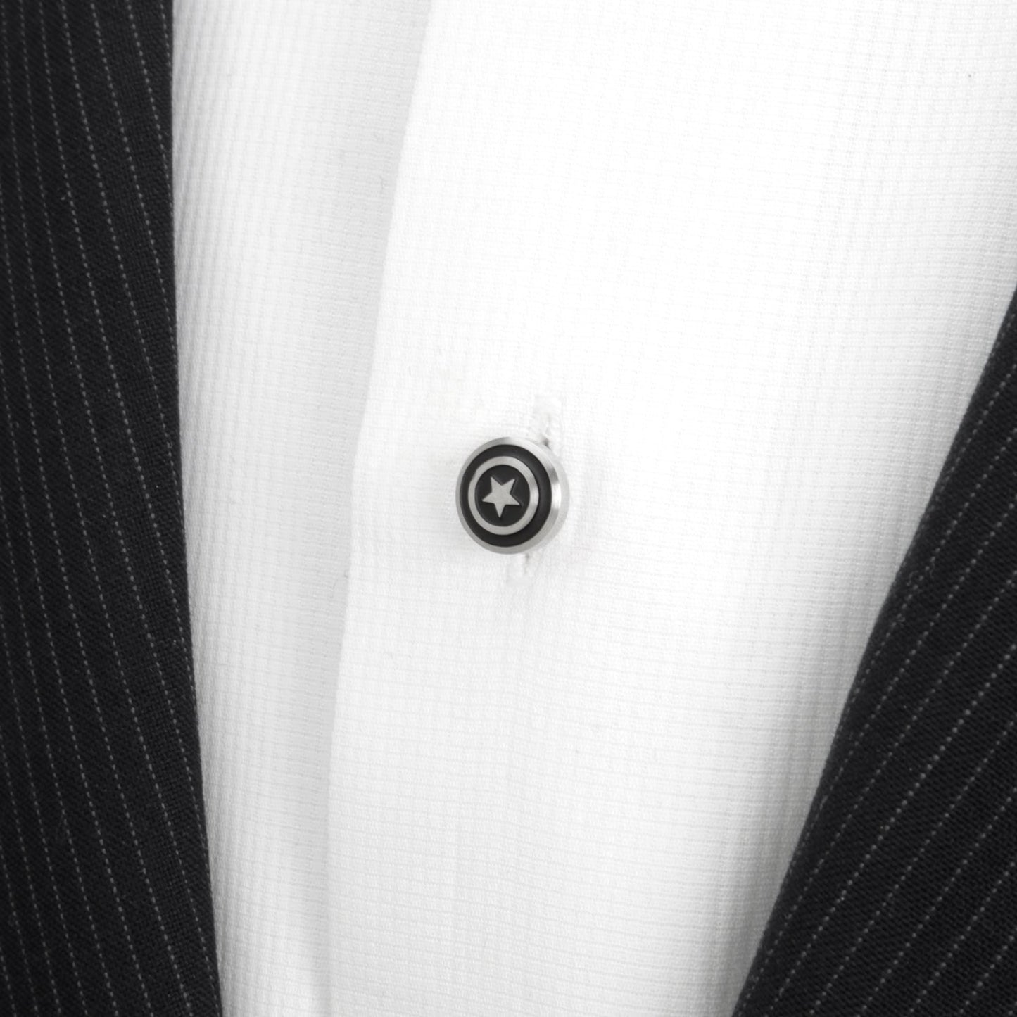 Close-up of a button on a black and white striped shirt with a star design.